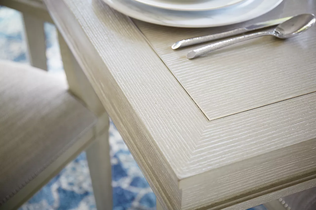 Closeup of the Hyde Park Dining Table and Armchair in Heather Grey in a room scene.
